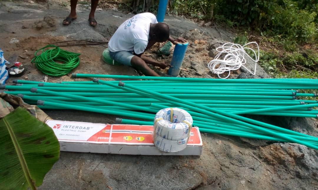 Engineer operating electrical testing equipment for a pump installation